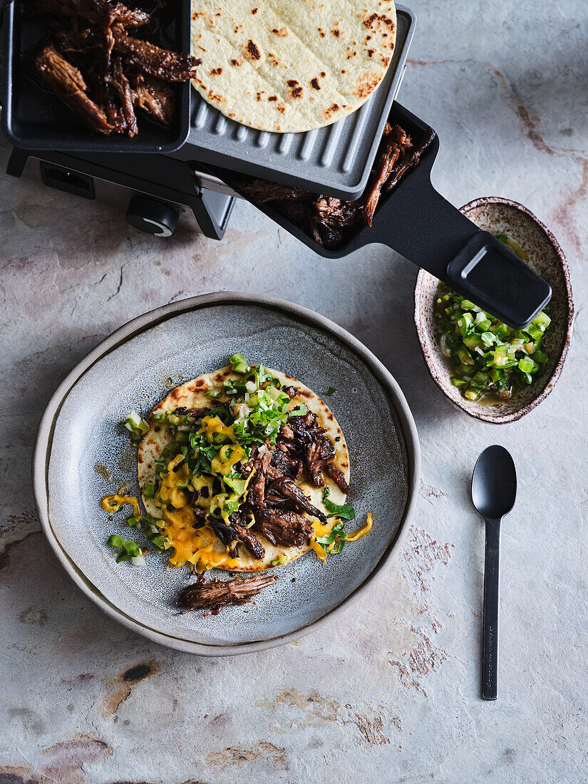 Mexikanisches Pulled Beef mit Cheddar aus dem Raclette mit Green-Tomatillos-Salsa