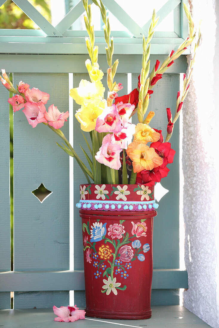 Gladioli in vintage umbrella stand with pompom trim