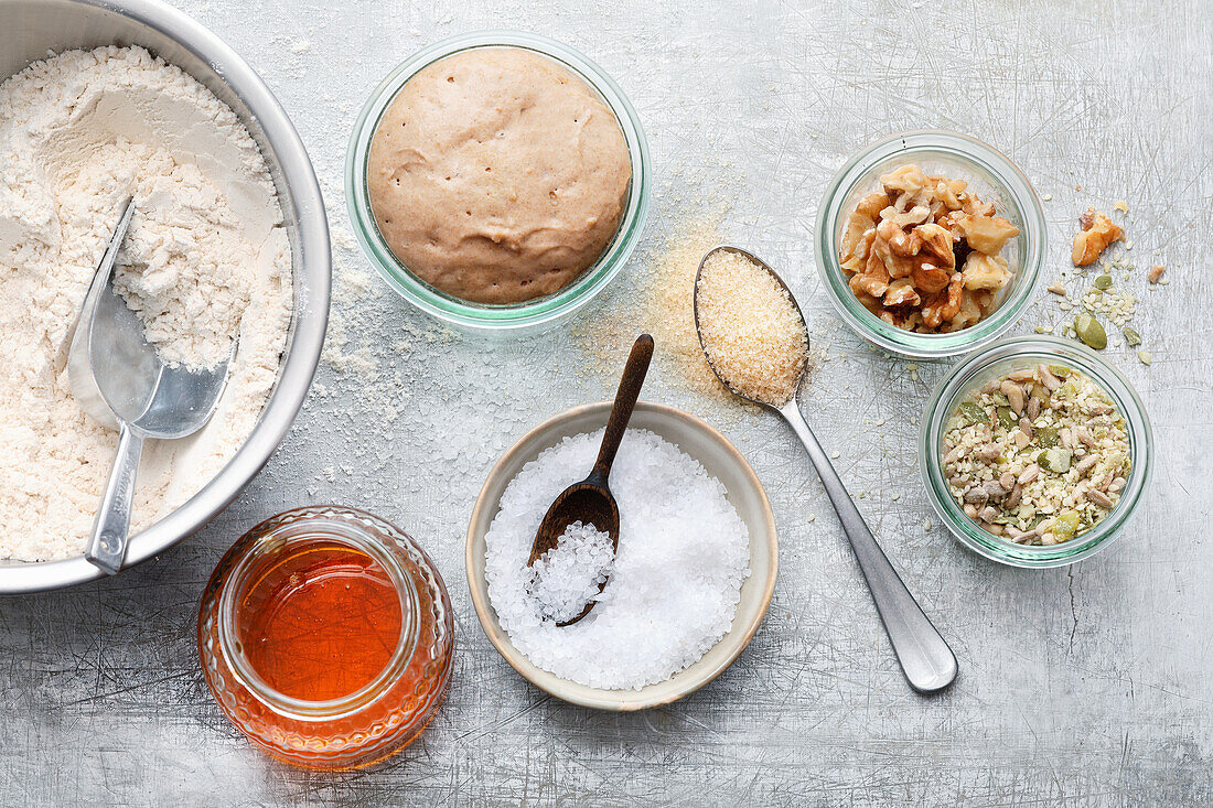 Bread ingredients - flour, sourdough, salt, nuts, seeds, honey, and cane sugar