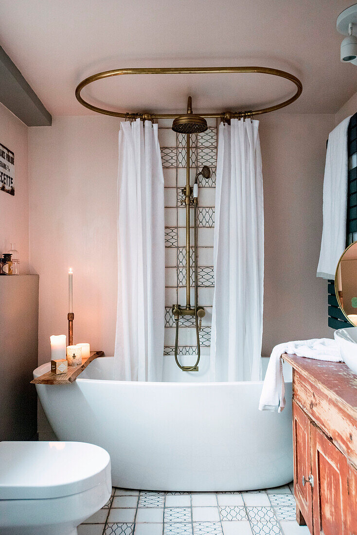 Badezimmer mit freistehender Badewanne, Vintage-Duscharmatur und alter Holzkommode