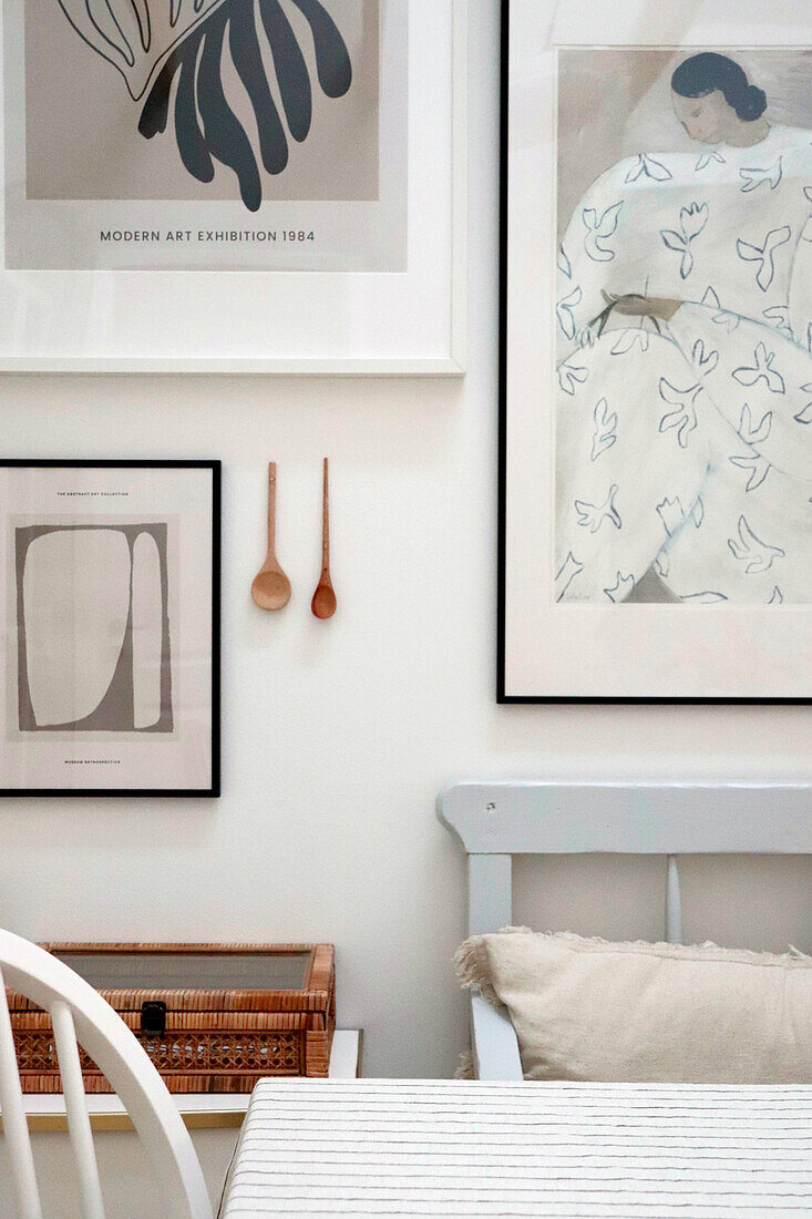 Wall design with framed artwork and wooden spoons in the dining area