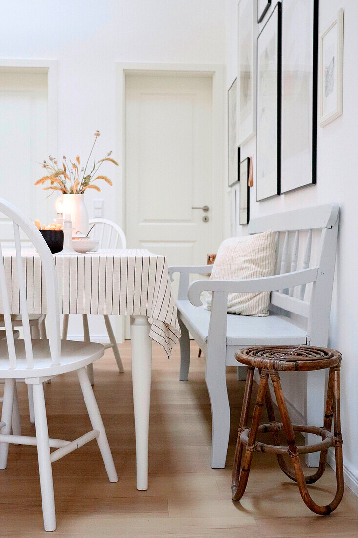 White dining table with chairs and bamboo stool