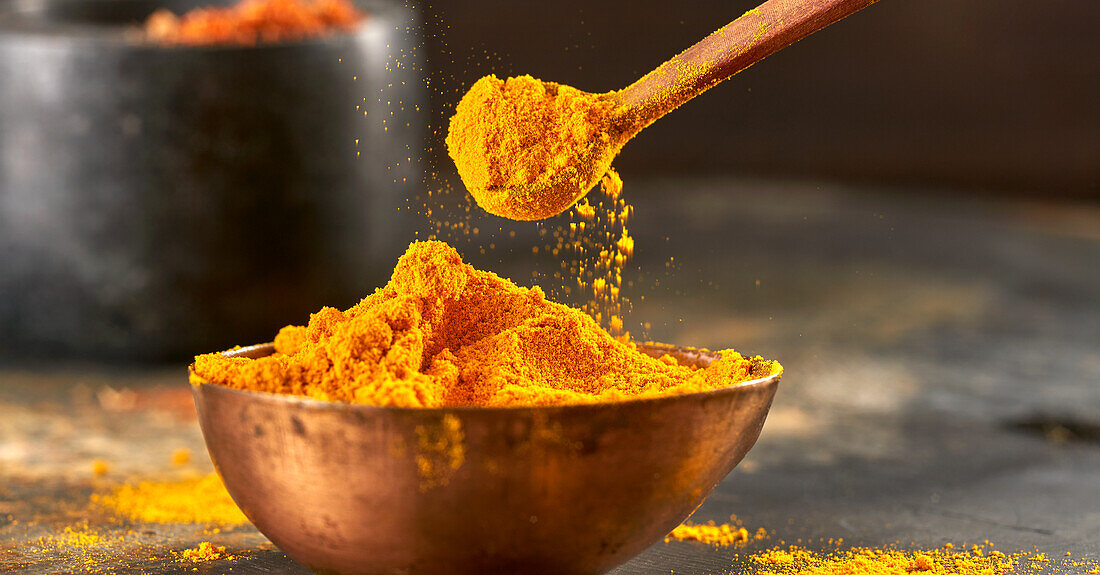 Currypulver auf Löffel und im Schälchen