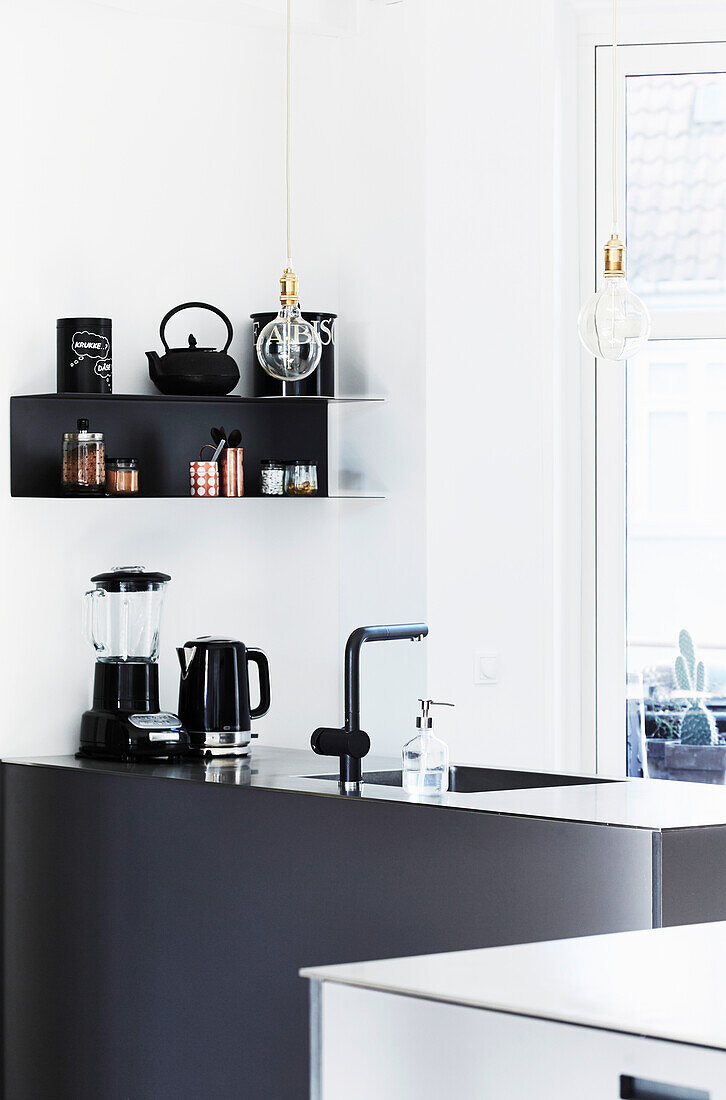 Black furniture in white, light-flooded kitchen