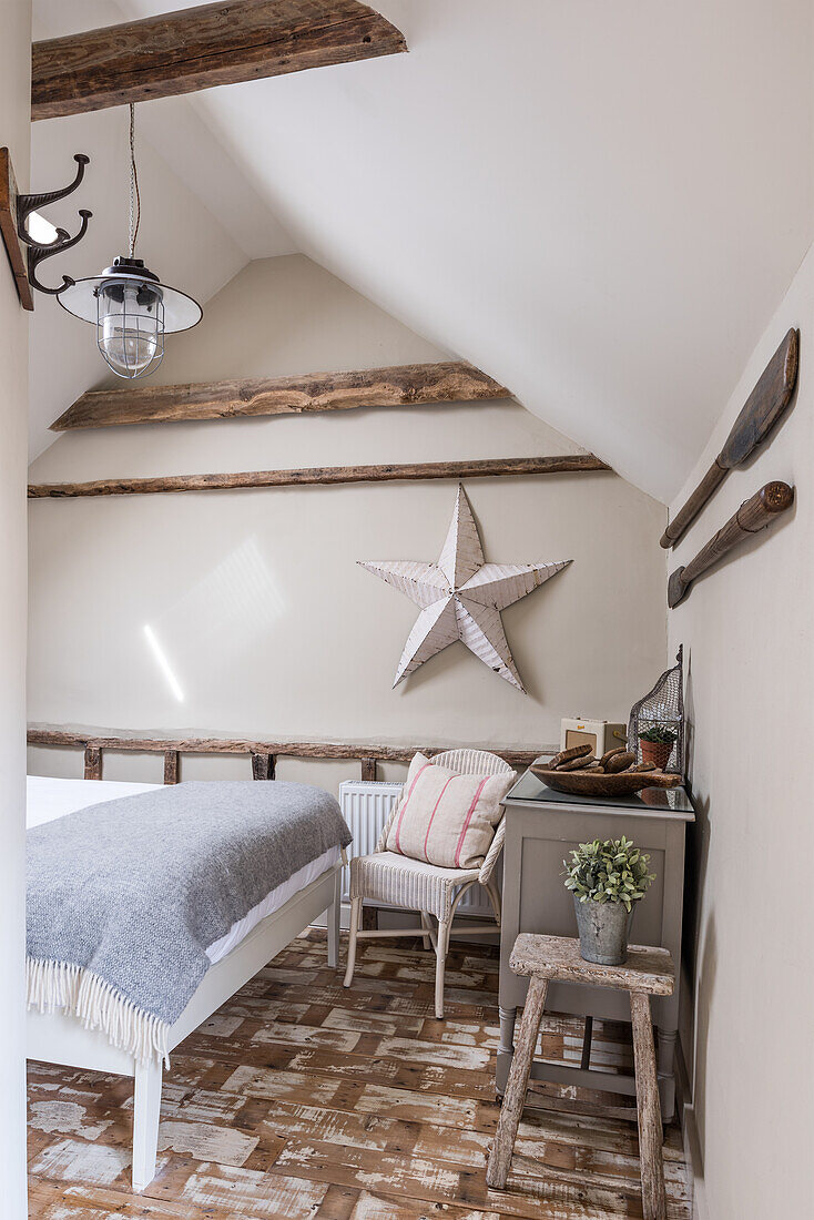 Country-style guest room under a sloping roof with single bed and star decor