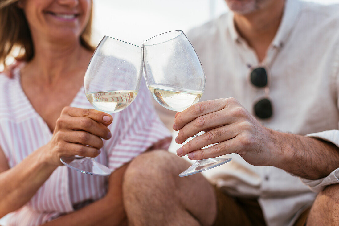 Älteres Paar Weintrinken bei Sonnenuntergang auf einem Segelboot