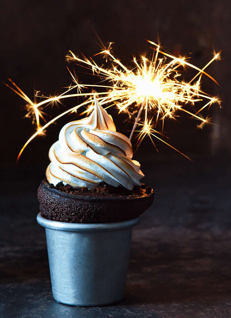 Chocolate soufflé with meringue topping and a sparkler