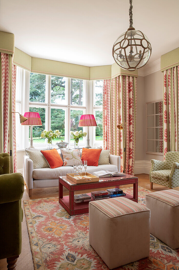 Classic living room with bay window, elegant curtains and beige-coloured sofa