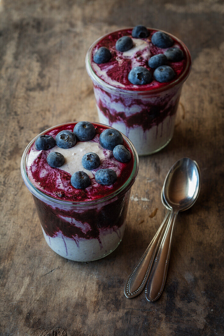 Cups of blueberry buckwheat porridge topped with blueberry on table