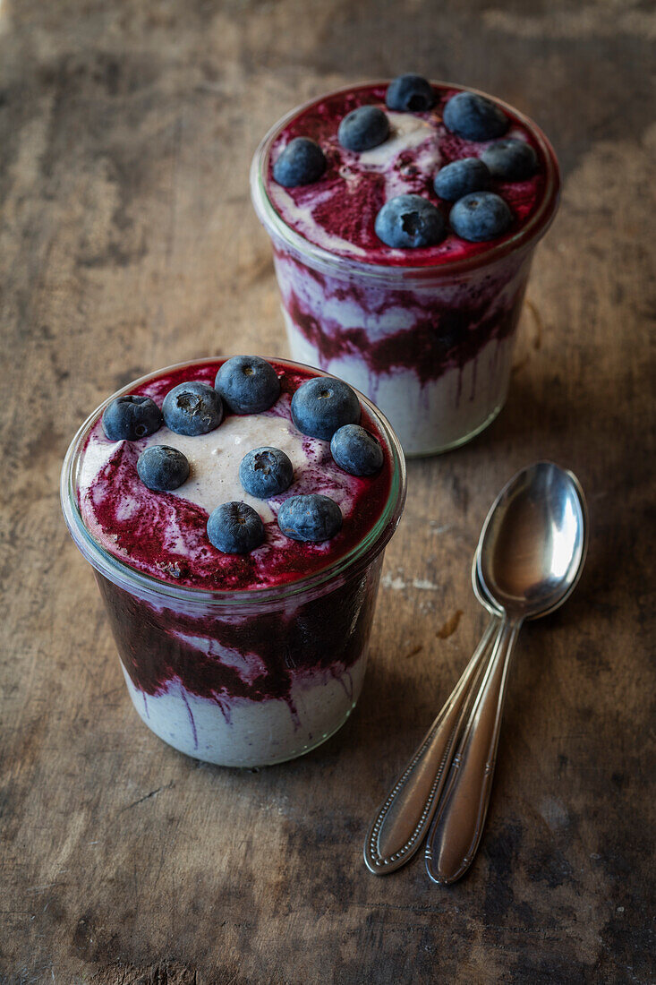 Zwei Gläser Blaubeer-Buchweizenbrei mit Blaubeeren auf dem Tisch