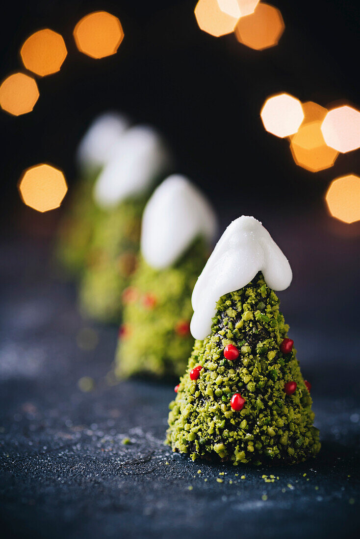 Schokoladenkuchen, weihnachtsbaumförmig, dekoriert mit Pistazien und Zuckerguss