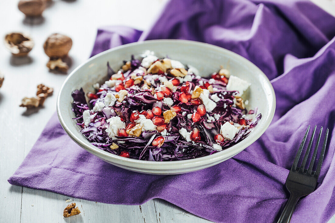 Schüssel Rotkohlsalat mit Granatapfelkernen, Walnüssen und Ziegenkäse