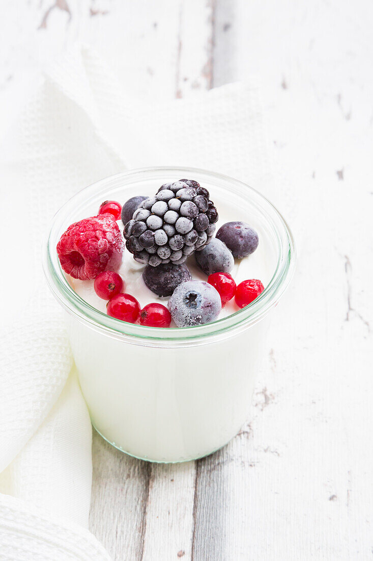 Glass of Greek yogurt with frozen berries