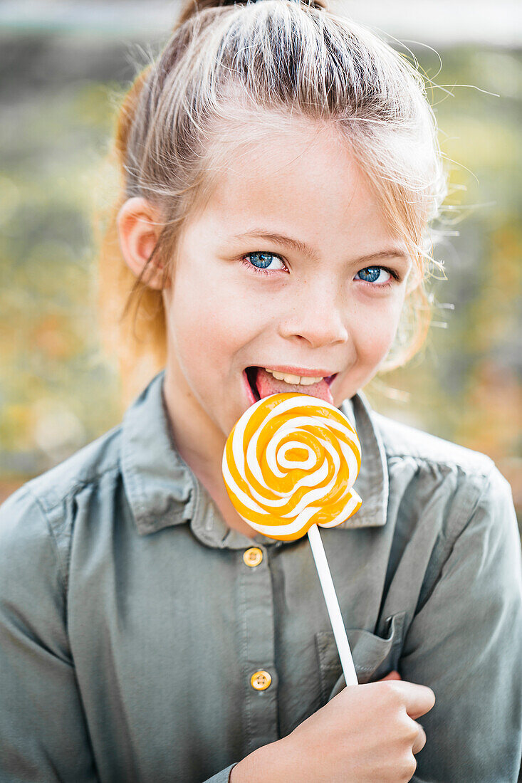 Portrait of girl licking lollipop