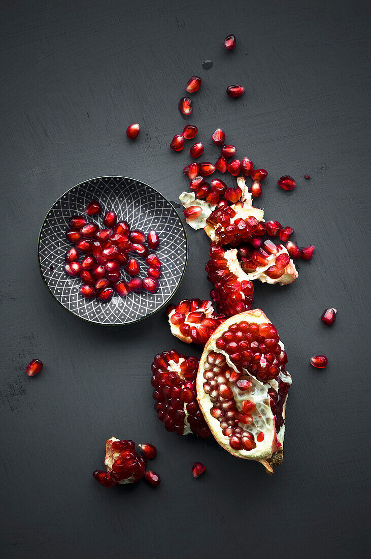Pomegranate and pomegranate seeds in bowl