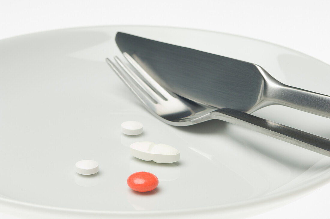 Pills on a plate with cutlery