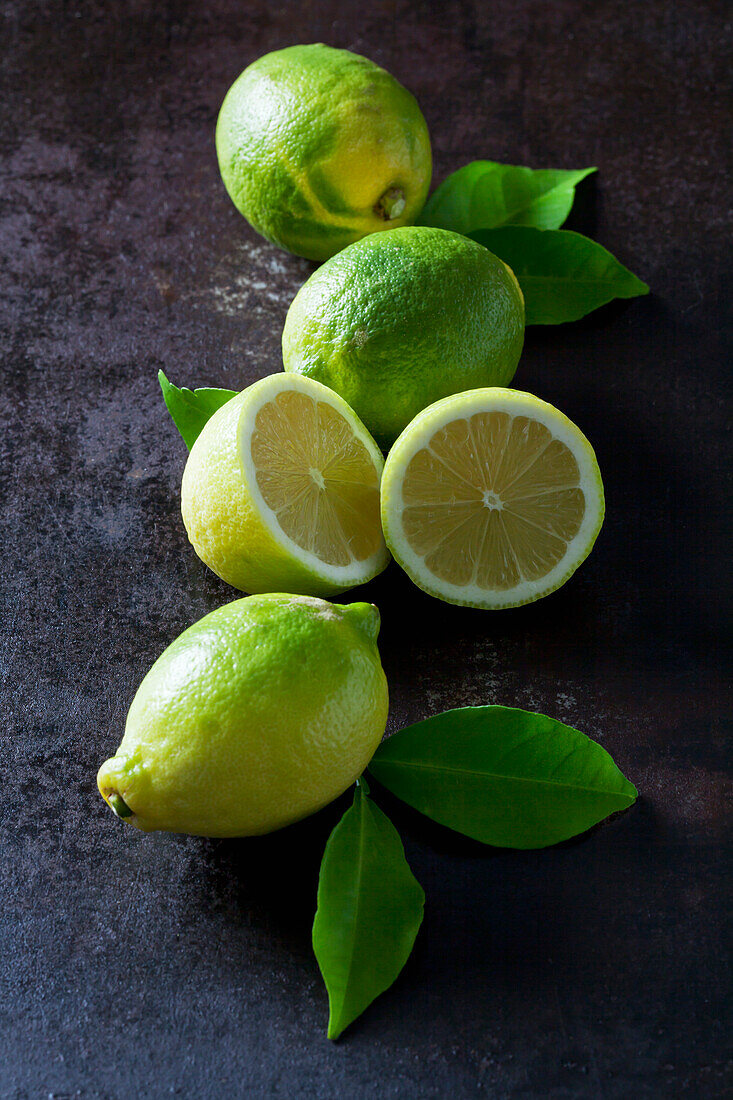 Green organic lemons on dark background