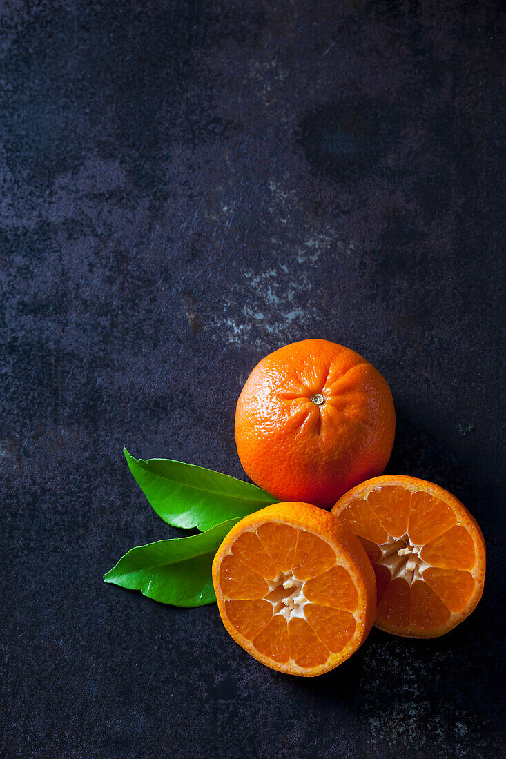 Geschnittene Mandarinen auf dunklem Hintergrund