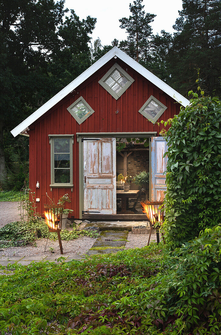 Feuerkörbe vor Holzhaus im Garten