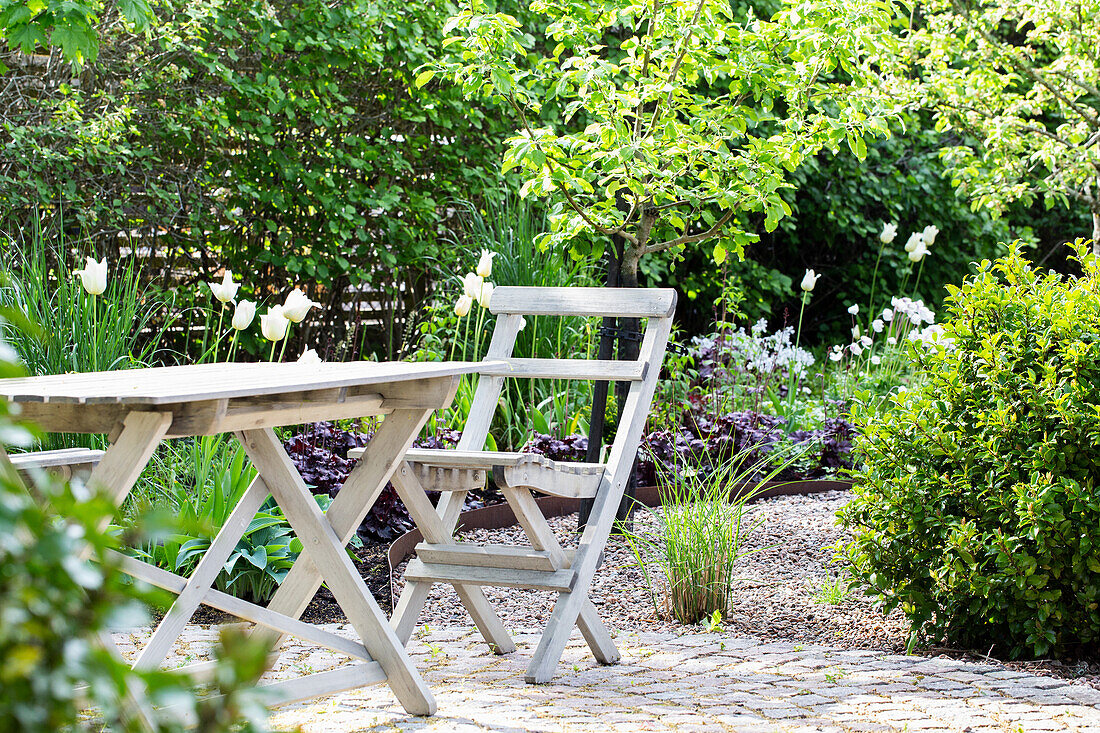 Seating area next to perennial plants in the garden