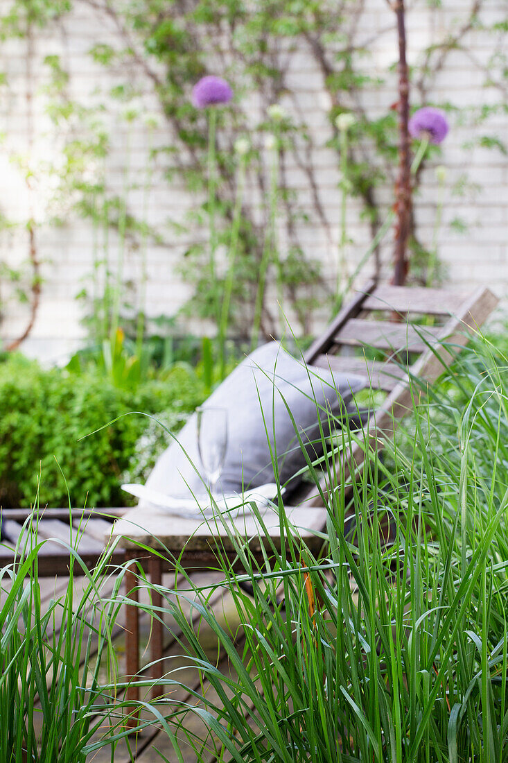 View through ornamental grass to lounger in a peaceful garden