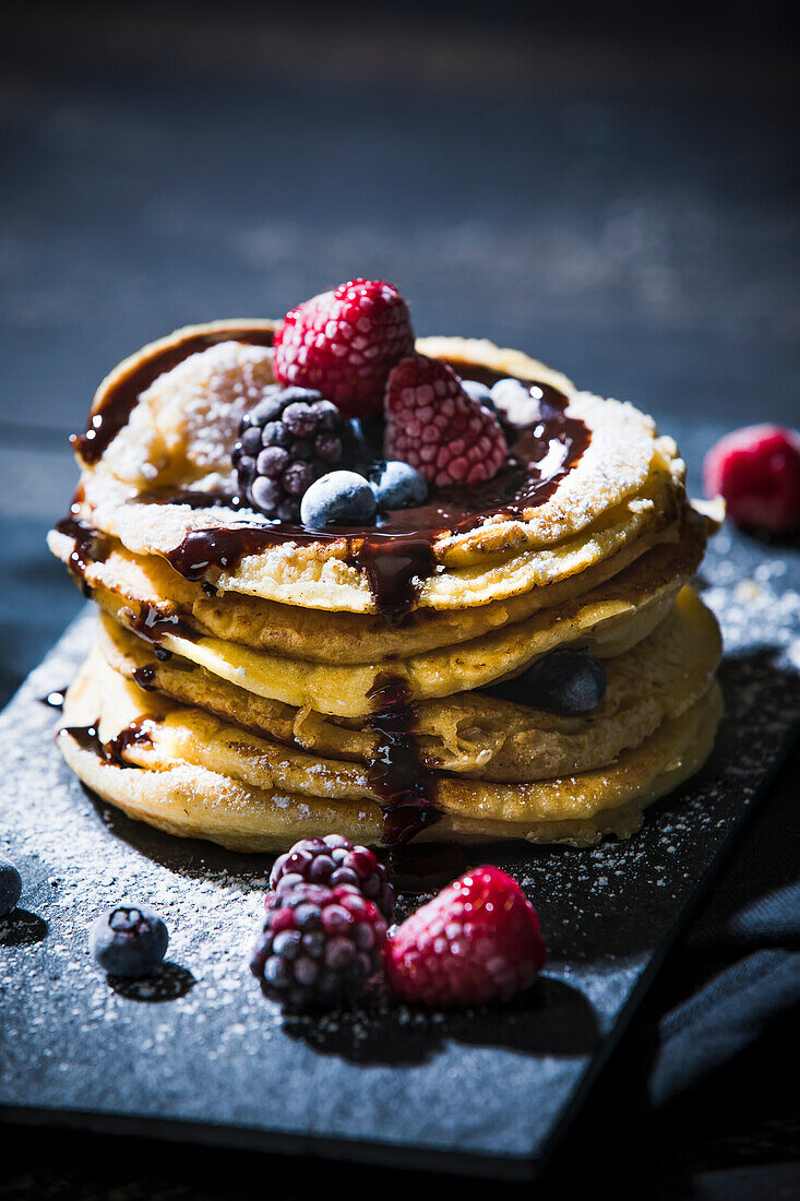 Pancakes with berries on plate at table