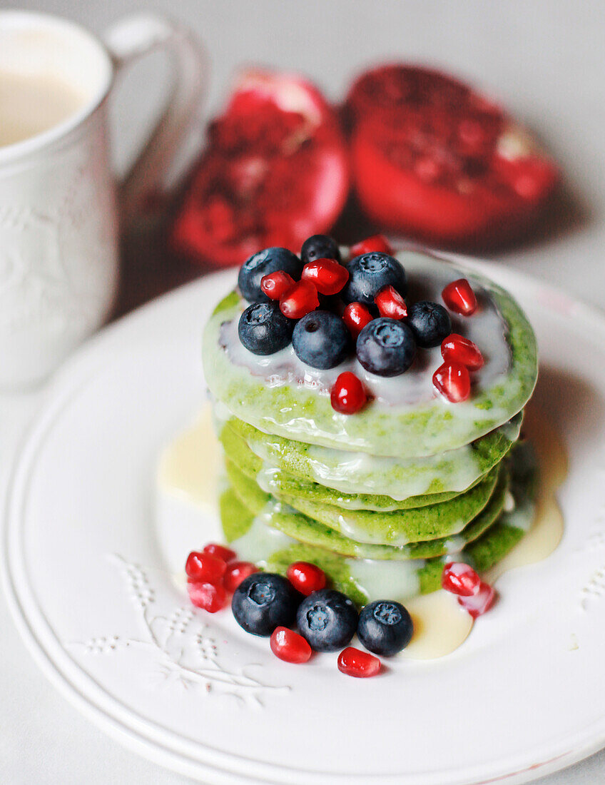Spinach pancakes with blueberries and pomegranate seeds