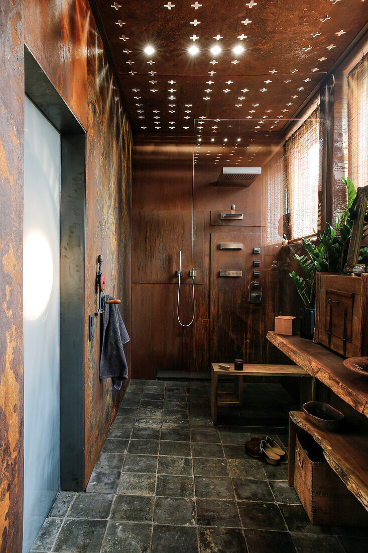 Modern bathroom with corten steel wall cladding and ceiling light effects