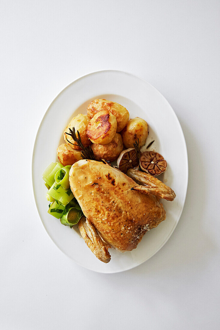 Gebratenes Hähnchen mit Kartoffeln, Lauch und ganzem Knoblauch