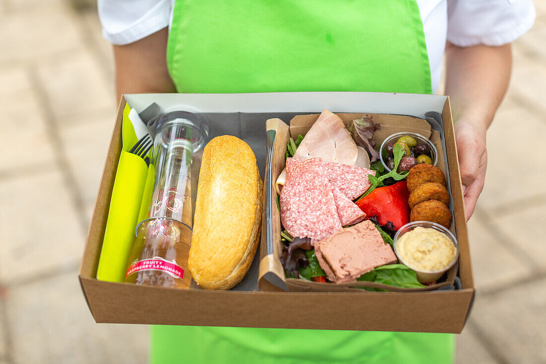 Lunchbox mit Brot, Falafel, Hummus, Wurst, Pastete und Salat