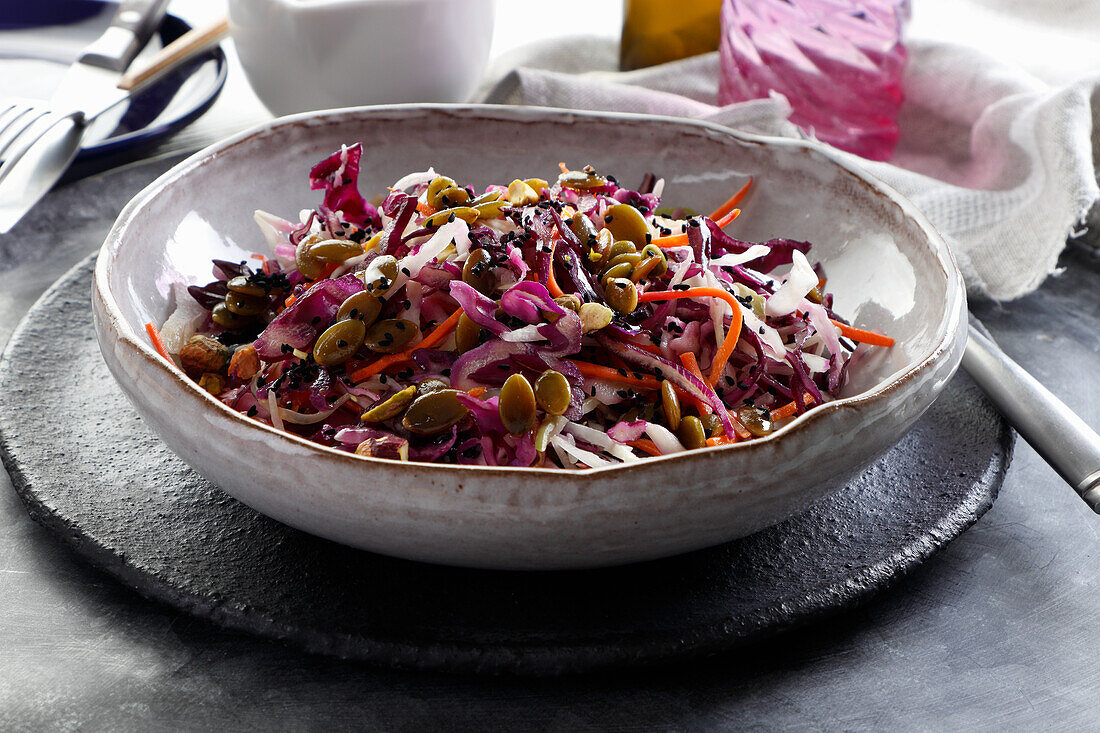 White and red cabbage salad sprinkled with pumpkin seeds and sesame seeds
