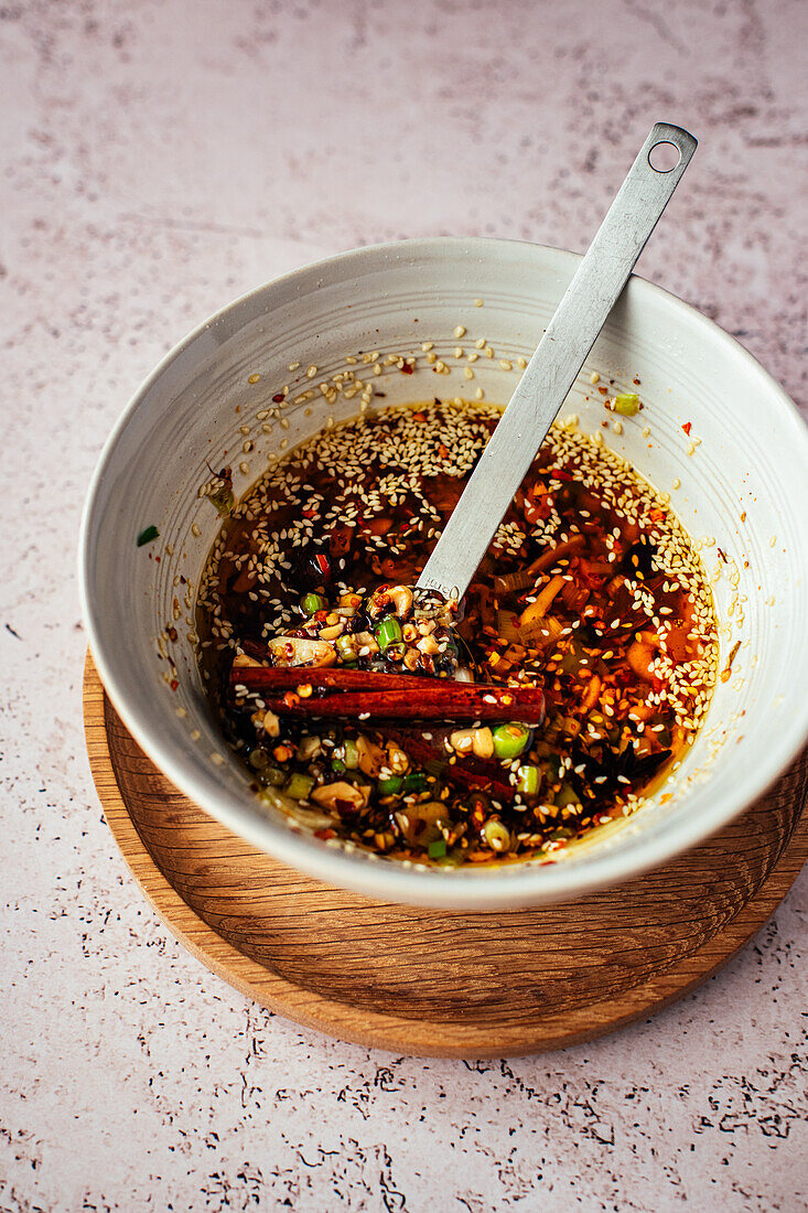 Homemade chili oil with Szechuan pepper, sesame, garlic, spring onions, peanuts, cinnamon and star anise