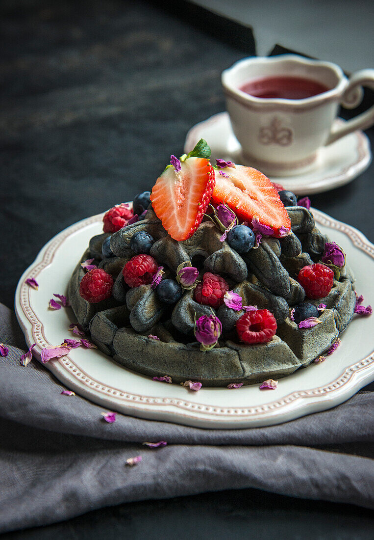 Black waffles with berries