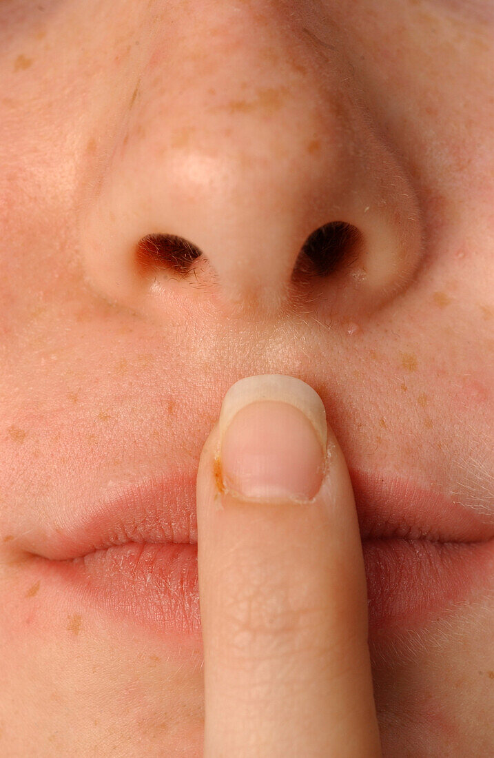 Girl with finger pressed against her lip