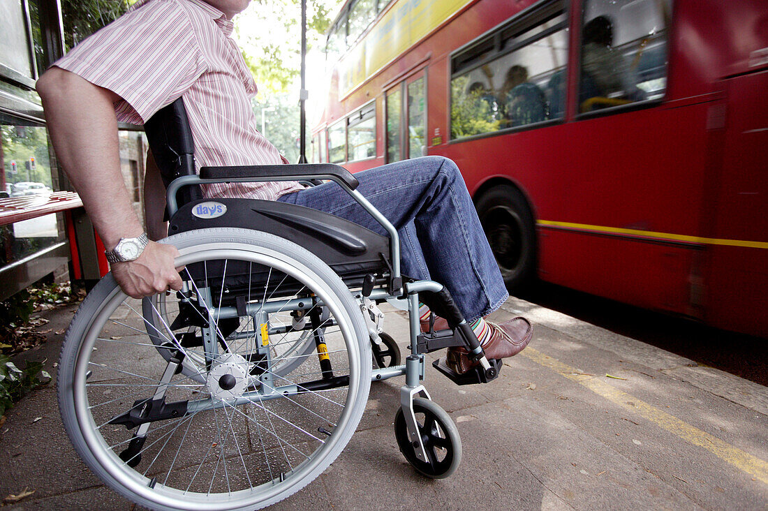 Man in a wheelchair at a bus stop