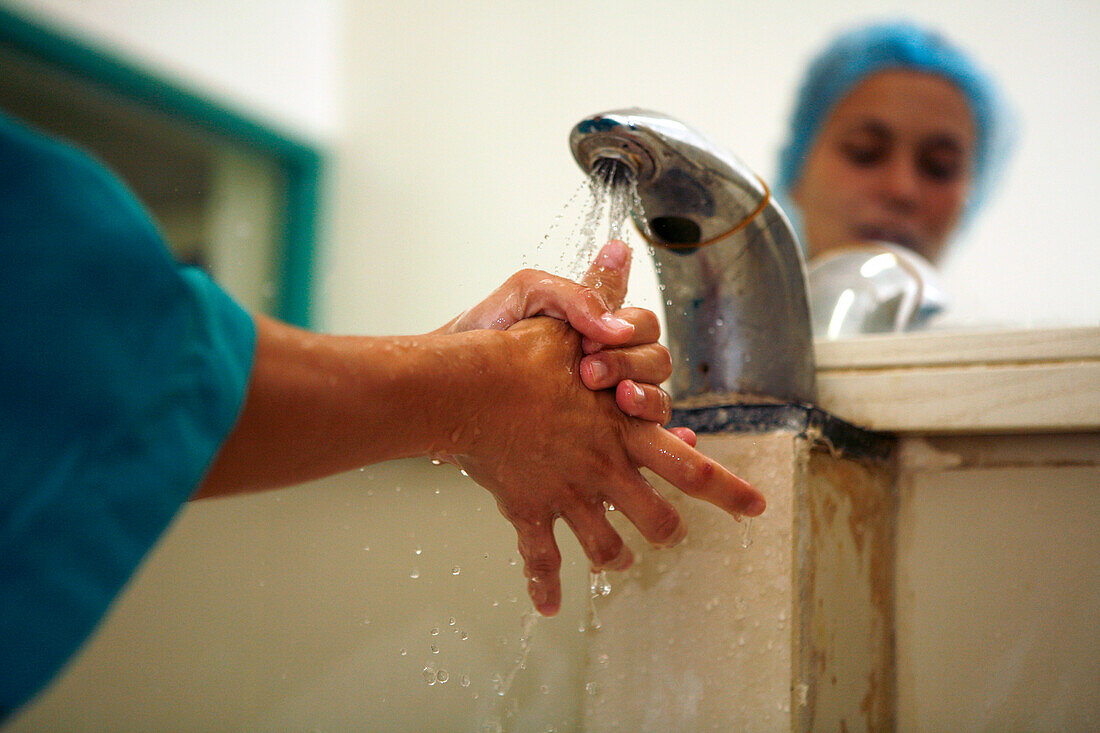 Surgeon washes her hands prior to surgery