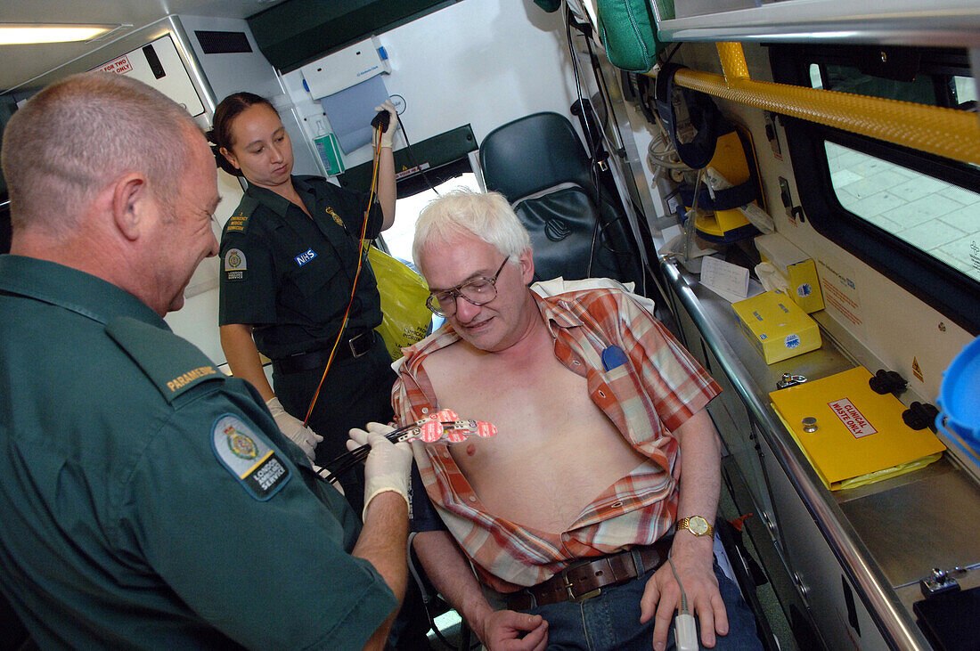 Paramedic attaching electrodes to his patient's chest