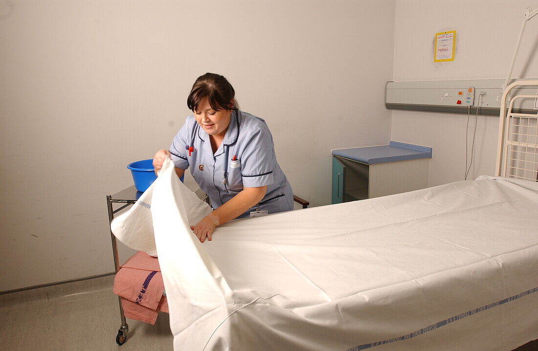 Staff nurse making a bed