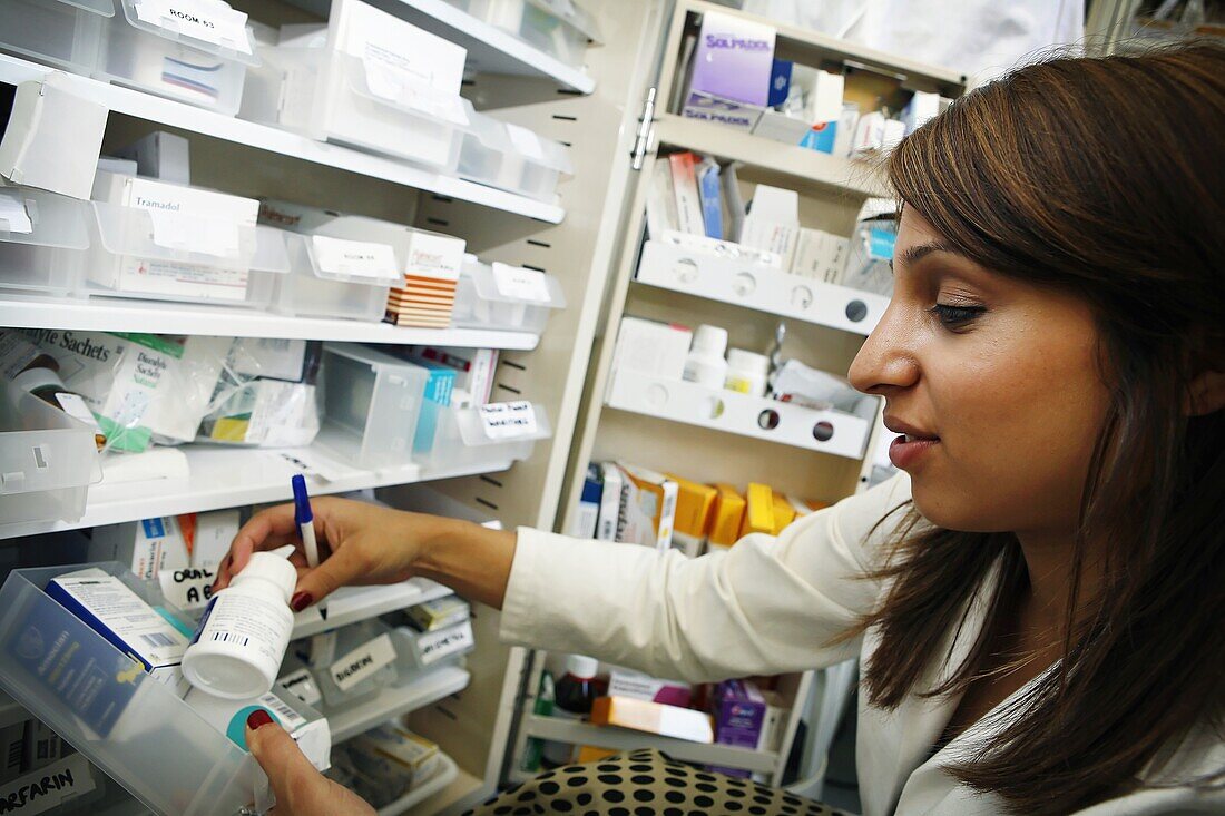 Young pharmacist selecting medication