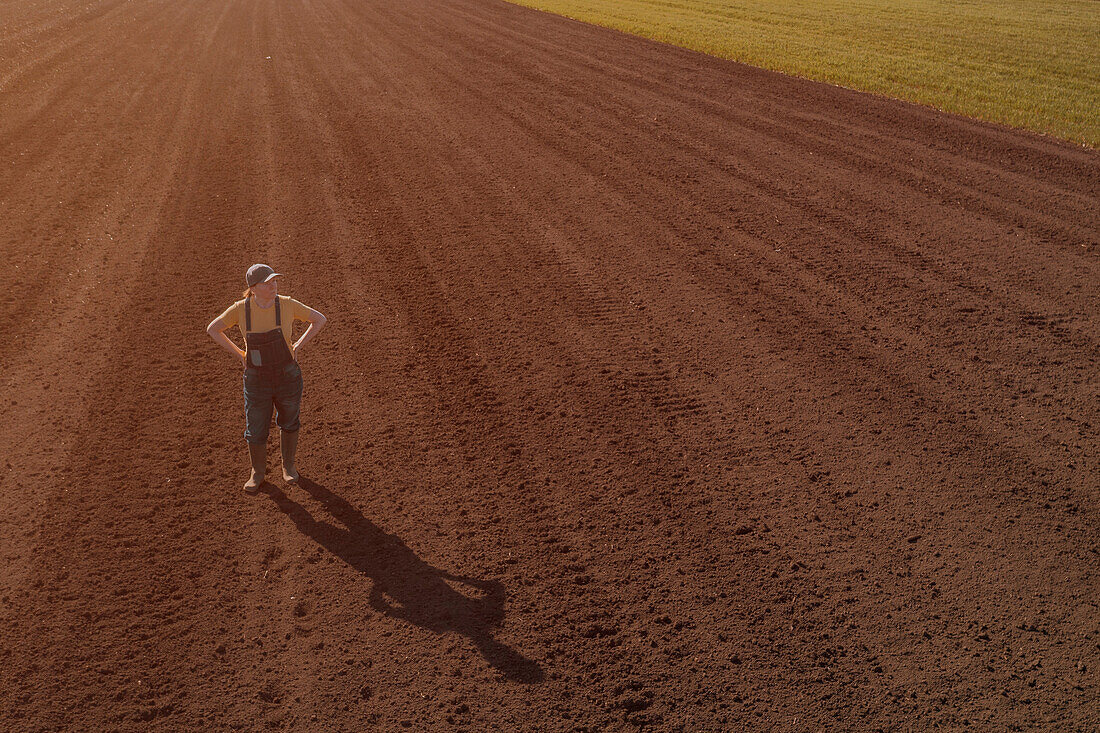 Farmer standing in ploughed field