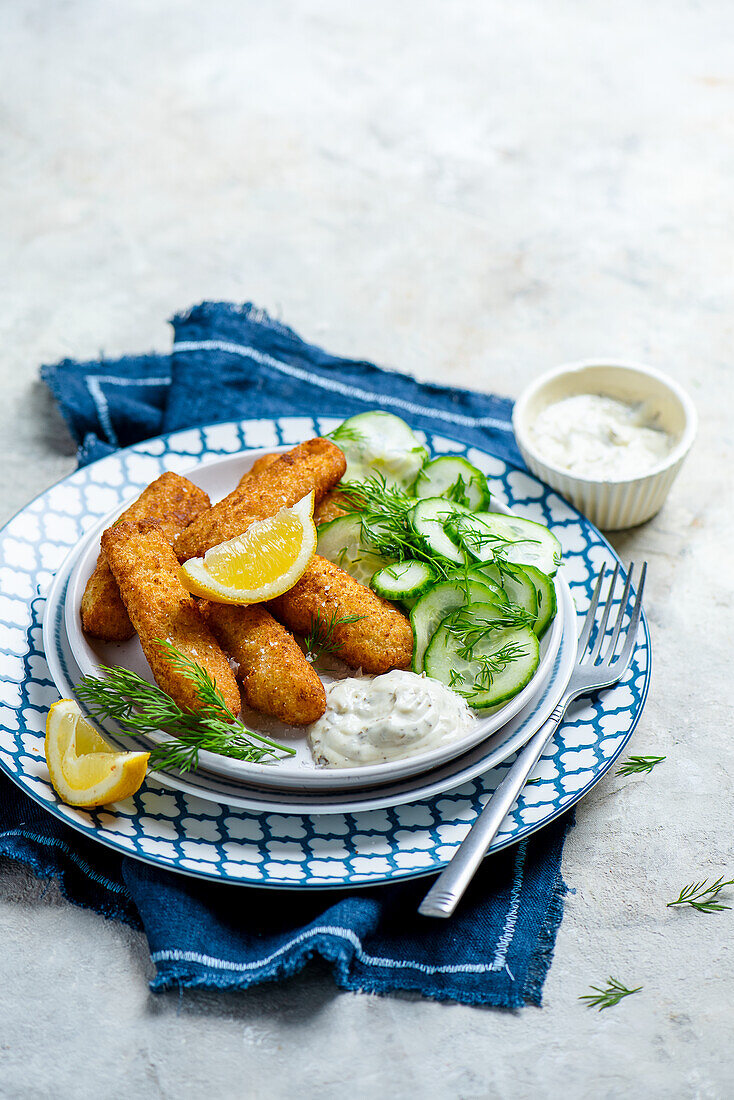 Fish sticks with tartar sauce and pickled cucumber slices