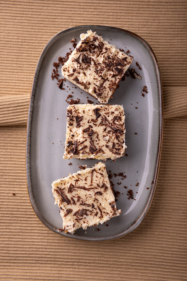 Vegan walnut-chocolate cake on a tray with vanilla cream