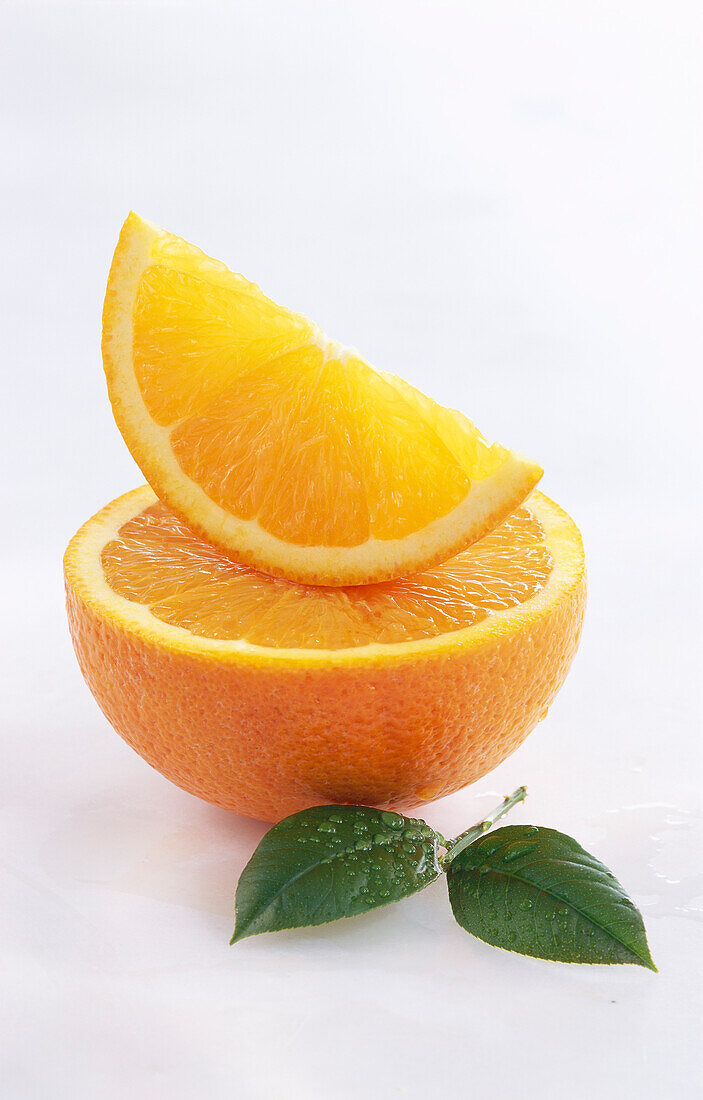 Orangenschnitz lliegt auf halbierter Orange