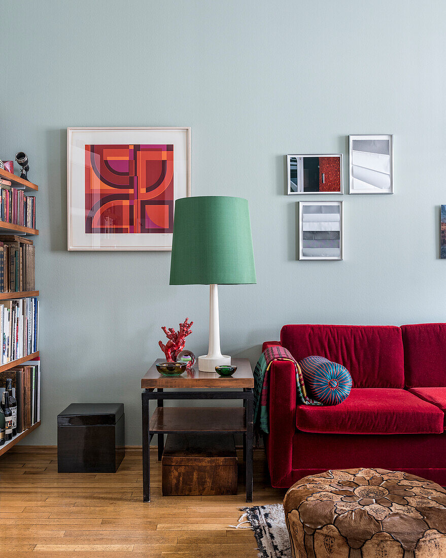 Red velvet sofa in eclectically furnished sitting room