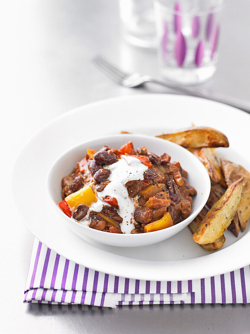 Mixed bean chilli with potato wedges