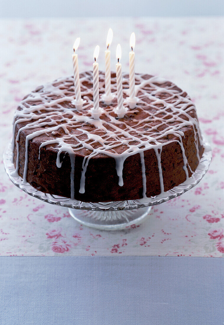 Festlicher Kuchen mit brennenden Kerzen