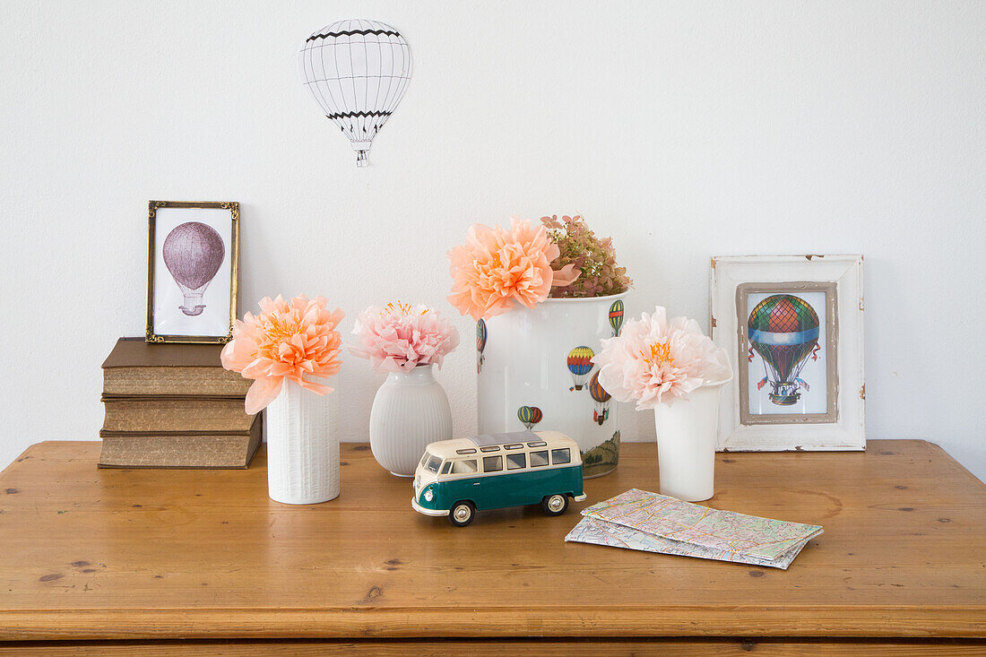 Decorated wooden table with vases, flowers and retro toy bus