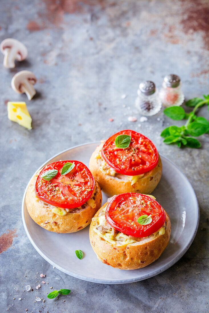 Überbacken Brötchen gefüllt mit Käse, Pilzen und Tomaten
