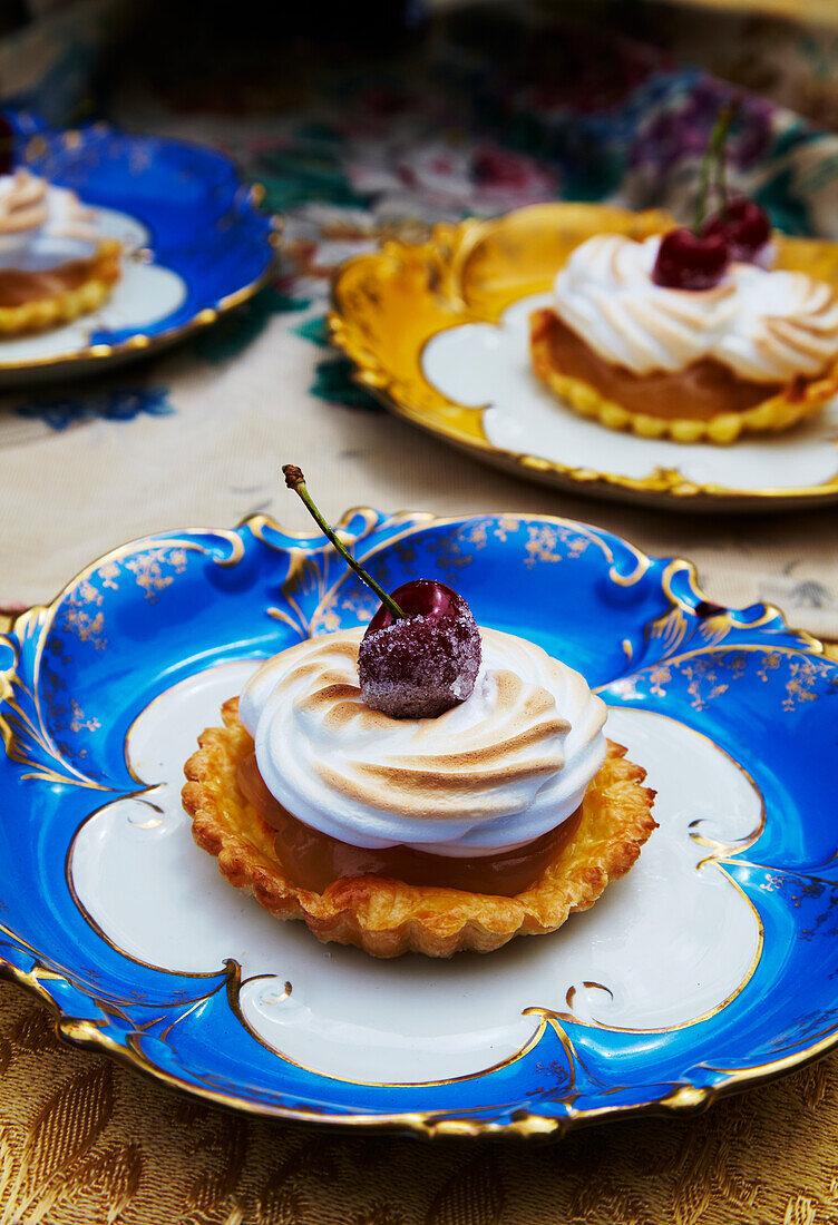 Lemon meringue tartlet decorated with a cherry