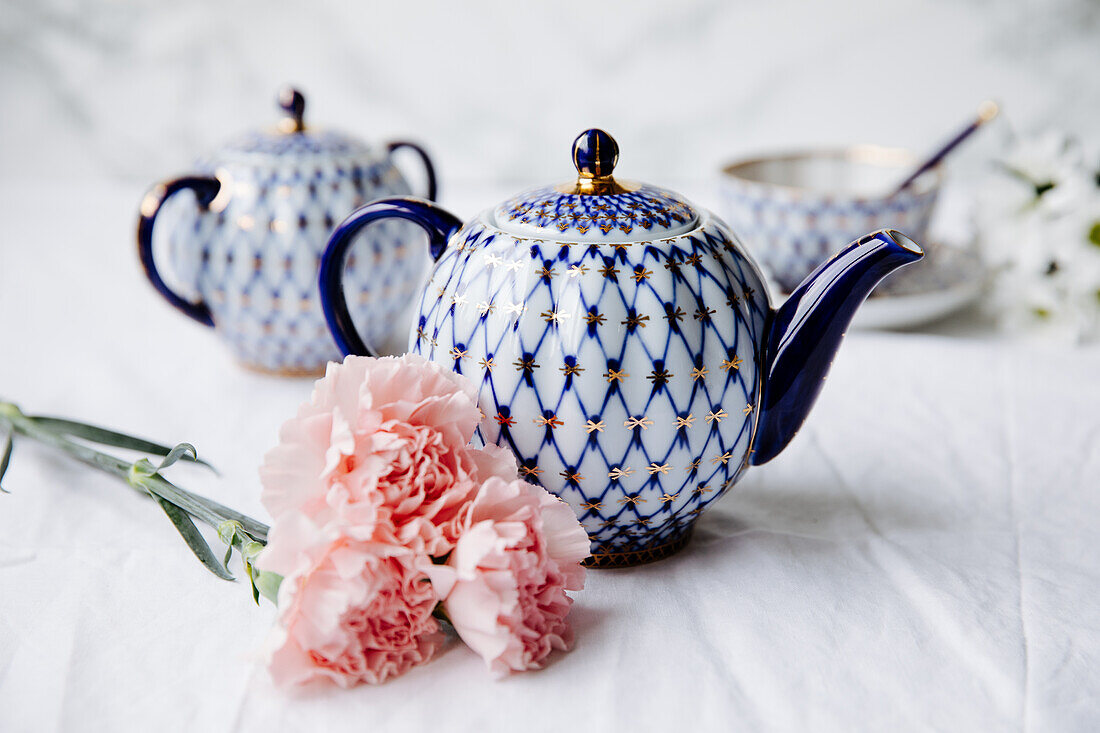 Decorative teapot with a blue-gold net pattern on a set table